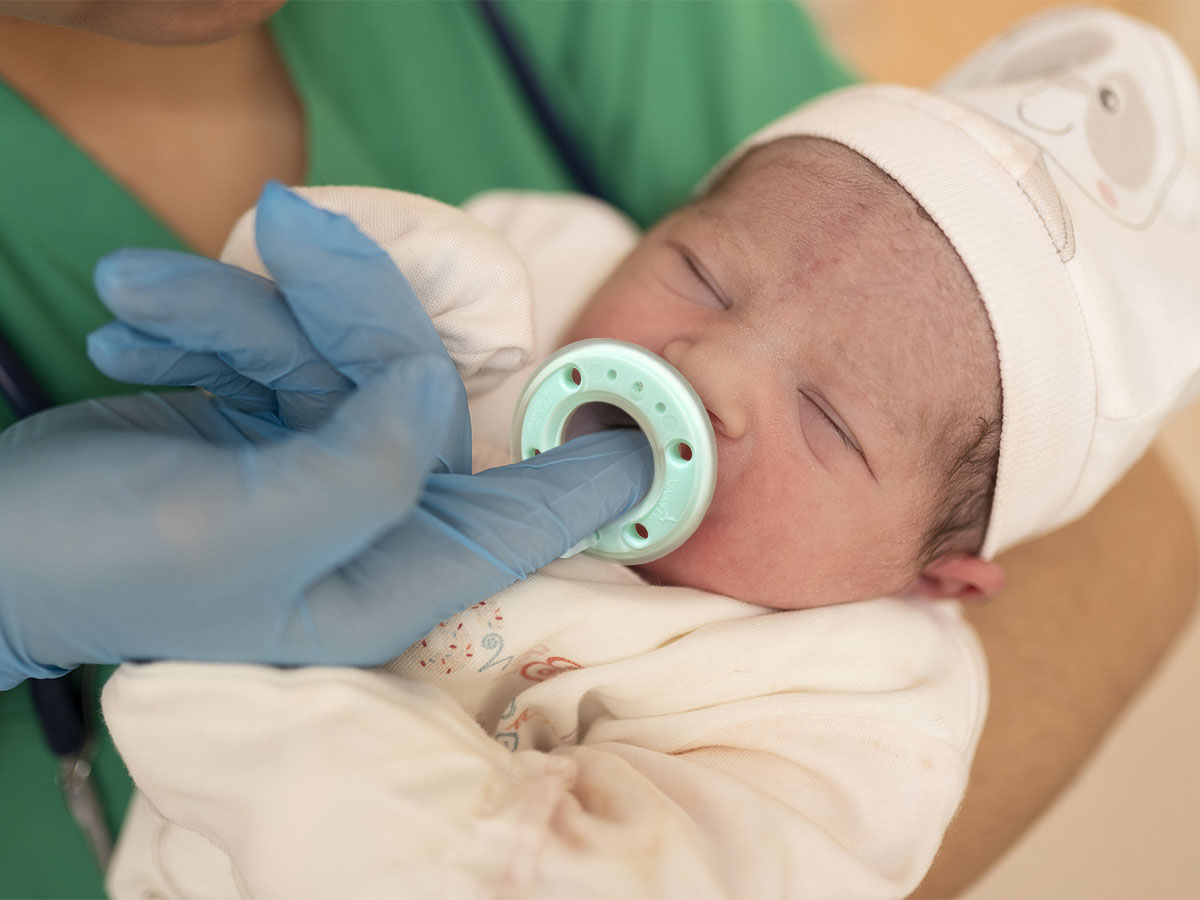 Nurse using Neotech Ninni breastfeeding pacifier with baby